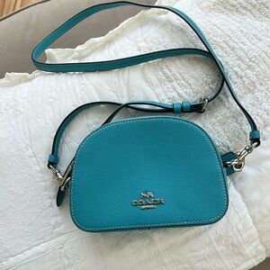 Turquoise blue Coach crossbody bag.